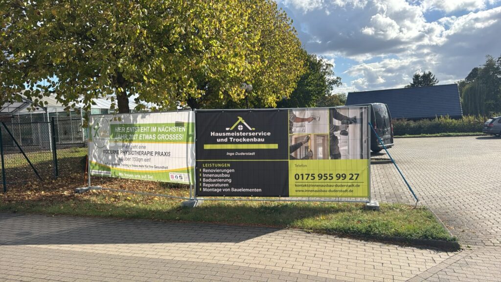 Schwarz-grünes Bauzaunbanner für Hausmeisterservice und Trockenbau Ingo Duderstadt mit Logo, Leistungen und Kontaktdaten.